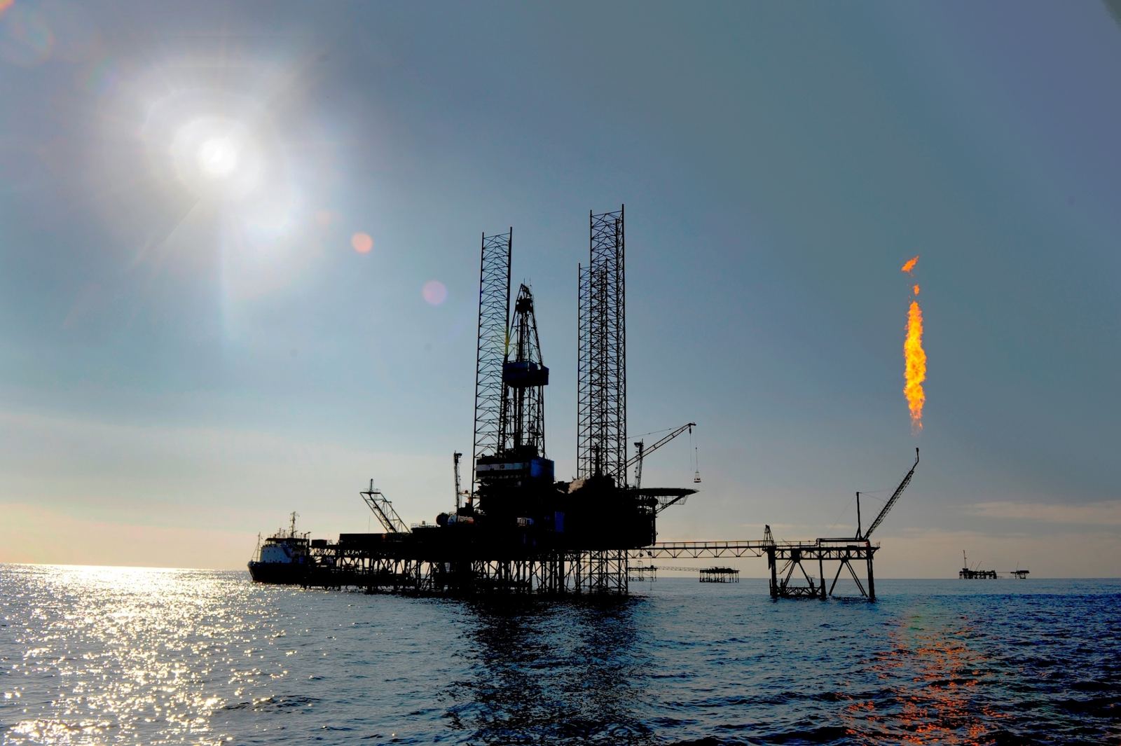 Jack-up drilling rig at sea with a gas flare