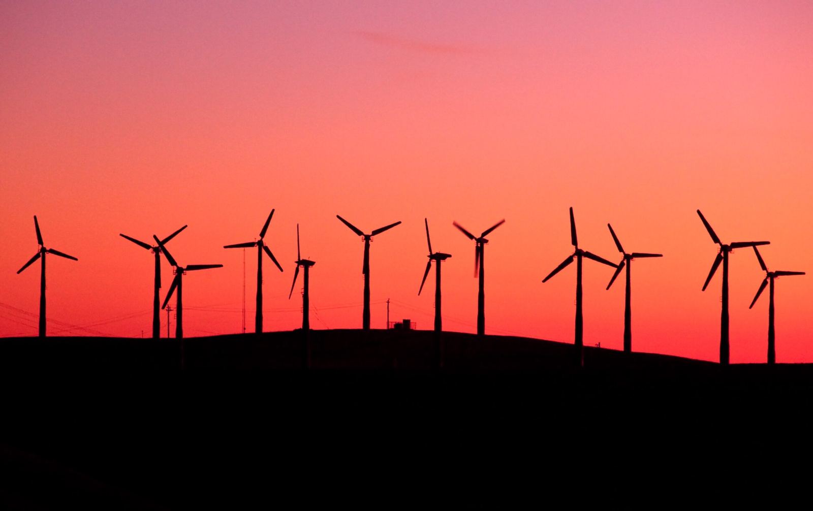 Wind turbines silhouetted on a ridge at dusk